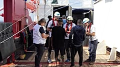 FILE PHOTO: Members of Doctors Without Borders (MSF) talk to migrants onboard Ocean Viking after a rescue operation, October 13, 2019. 