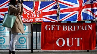Una mujer toma fotos al lado de las pancartas pro-Brexit frente a las Cámaras del Parlamento en Londres, Reino Unido, el 28 de octubre de 2019.