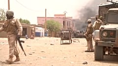 FILE:  Soldiers stand guard as smoke rises in the distance after a car bomb attack in Gao, northern Mali July 1, 2018. 