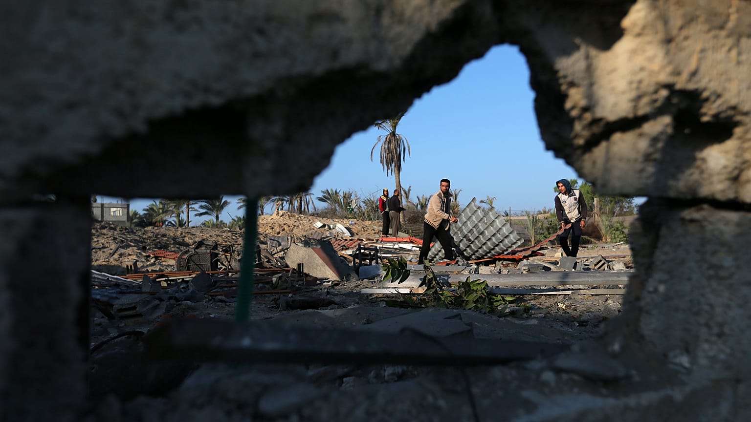 Palestinians inspect a site belonging to Hamas after it was targeted by Israeli warplanes