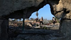 Palestinians inspect a site belonging to Hamas after it was targeted by Israeli warplanes