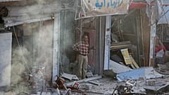 مواطن سوري ينظر إلى السيارة المففخة التي انفجرت في سوق مدينة تل أبيض شمال سوريا. السبت 02/11/2019