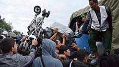 Μέλη ευάλωτων οικογενειών φορτώνουν τα υπάρχοντά τους σε φορτηγά από τη Μόρια