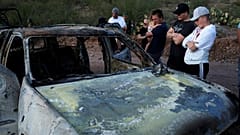 Parenti delle vittime osservano sgomenti uno delle auto carbonizzate. 