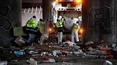 Workers clean the site after a migrant makeshift camp was evacuated under the Porte de la Villette ring bridge in Paris, France.