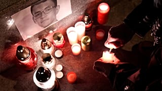 A journalist lights a candle in memory of murdered investigative journalist Jan Kuciak, in Trencin, Slovakia, February 26, 2018. 