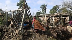 A woman cleans her house damaged by Cyclone Bulbul in Bakkhali on November 10, 2019