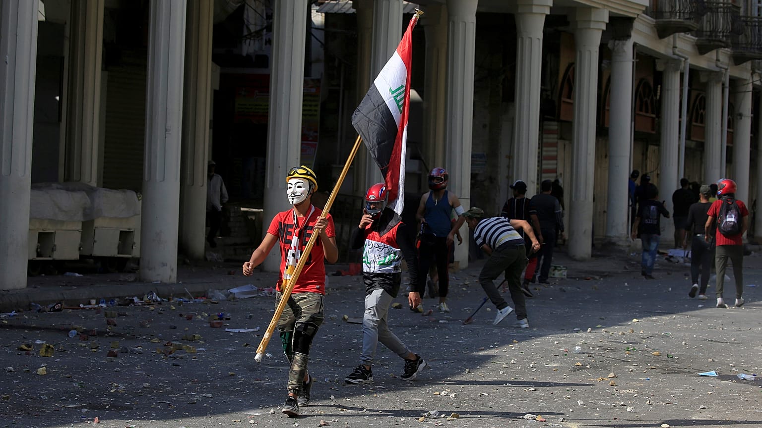 أحد المتظاهرين يحمل العلم العراقي خلال الاحتجاجات المناهضة للحكومة في بغداد، العراق في 7 نوفمبر/ تشرين الثاني 2019