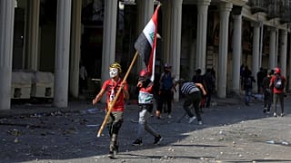 أحد المتظاهرين يحمل العلم العراقي خلال الاحتجاجات المناهضة للحكومة في بغداد، العراق في 7 نوفمبر/ تشرين الثاني 2019