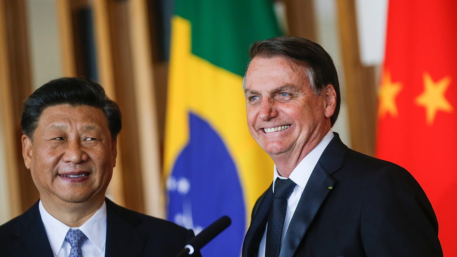 Brazil's President Jair Bolsonaro reacts next to China's President Xi Jinping as they deliver a joint statement after a bilateral meeting during the BRICS summit in Brasilia