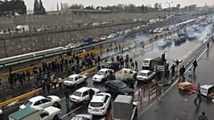 People stop their cars in a highway to show their protest for increased gas price in Tehran, Iran
