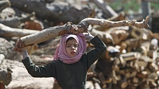 فتاة تحمل الحطب في أحد الأسواق في ظل نقص الوقود وغاز الطهي في صنعاء باليمن
