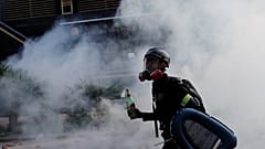 Ein Demonstrant schützt sich mit Gasmaske vor dem Rauch