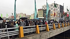 People stands in the street to show their protest against increased gas price in Tehran
