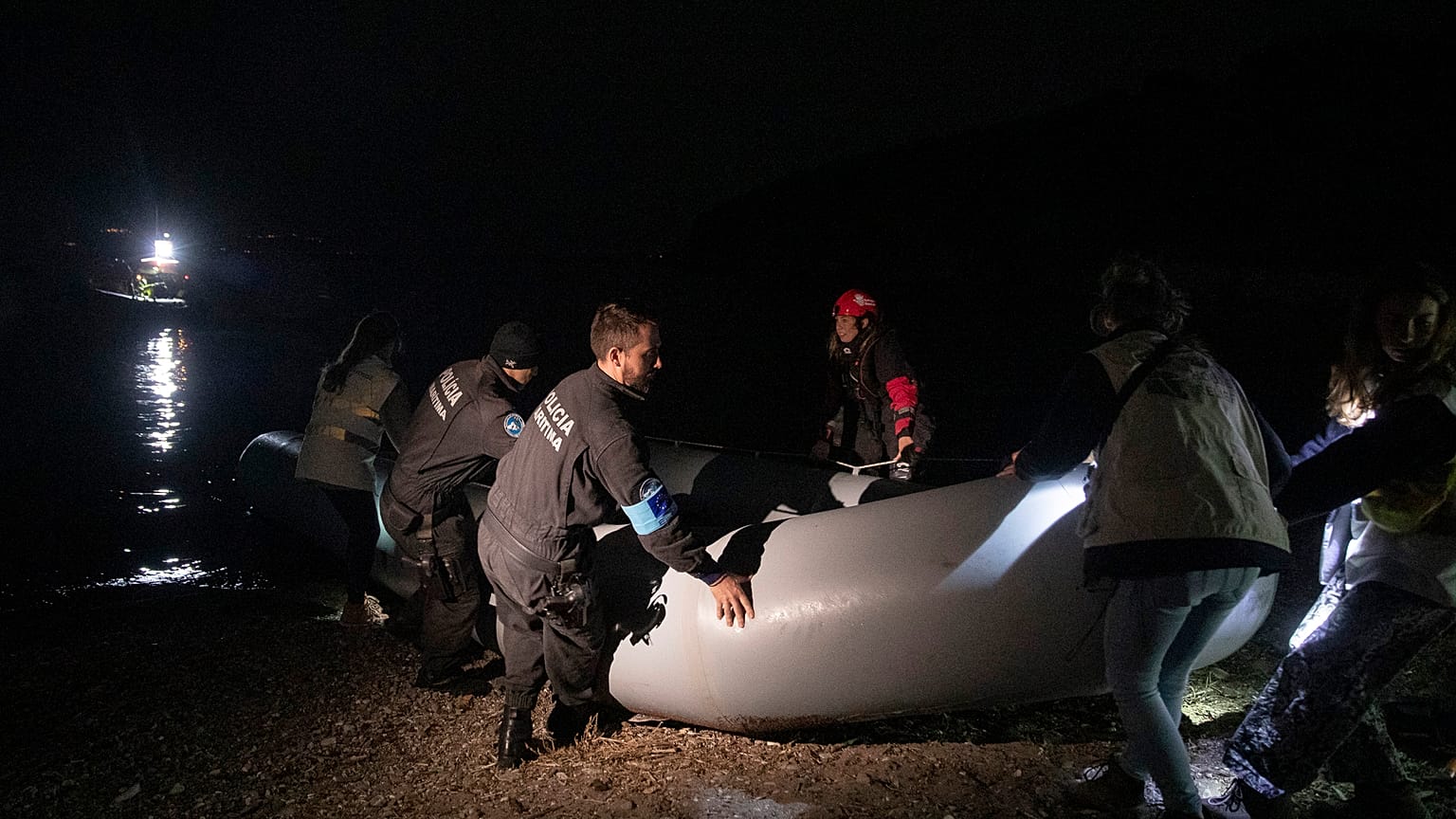 Αστυνομικοί και διασώστες απομακρύνουν φουσκωτή βάρκα μετά την άφιξη προσφύγων και μεταναστών στη Σκάλα Συκαμιάς(ΑΡΧΕΙΟΥ)
