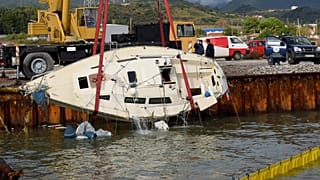 Γερανός ανασύρει το ιστιοφόρο μετά την ανατροπή του  στην ανατολική προβλήτα του Αντιρρίου