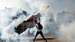 متظاهر فلسطيني يعيد قنبلة الغاز بالقرب من مستوطنة بيت إيل، الضفة الغربية- أرشيف رويترز
