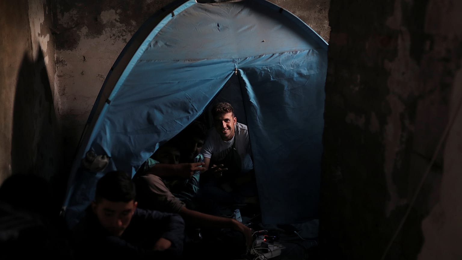 Migrantes de Afganistán sentados en su tienda de campaña en una imprenta abandonada cerca de la frontera croata, cerca de la ciudad de Sid, Serbia, el 4 de septiembre de 2019.