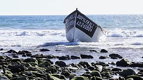 Sunseekers spring into action as migrants arrive at Spanish beach