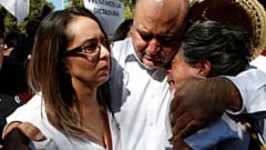 Julián LeBarón abraza a dos mujeres durante la protesta por el aniversario de la presidencia de López Obrador