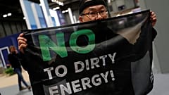 An activist protests as part of the Make Big Polluters Pay campaign inside the venue of the U.N. climate change conference (COP25) in Madrid, Spain, December 4, 2019