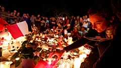 Gyászolók a terrortámadás áldozataira emlékeznek 2016. július 15-én éjjel a dél-franciaországi Nizza tengerparti sétányán