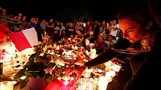 Gyászolók a terrortámadás áldozataira emlékeznek 2016. július 15-én éjjel a dél-franciaországi Nizza tengerparti sétányán