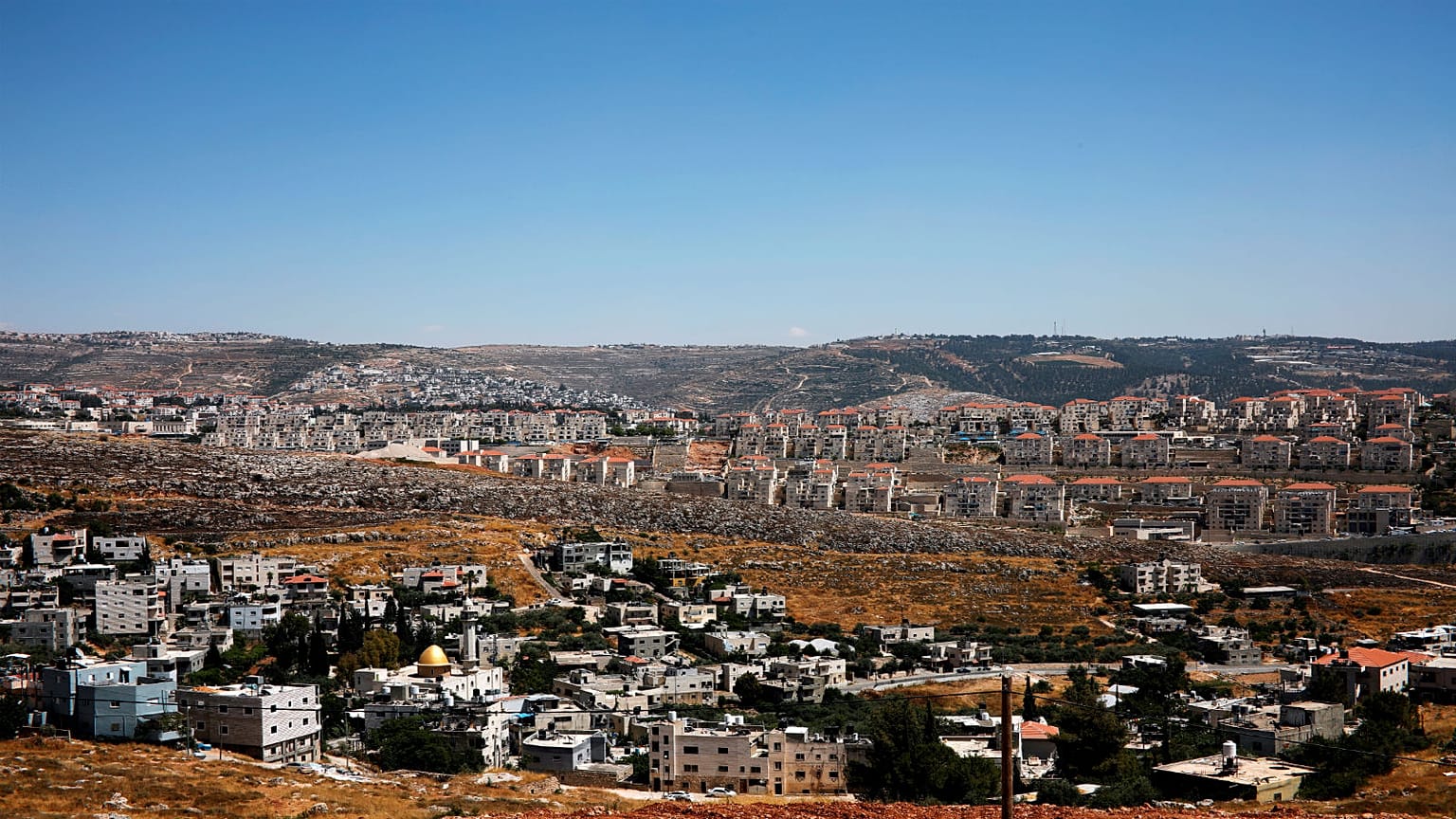 منازل فلسطينيين في قرية فوكين وفي الخلفية مستوطنة بيطار اليت الإسرائيلية في الضفة الغربية المحتلة -2019/06/19 – 