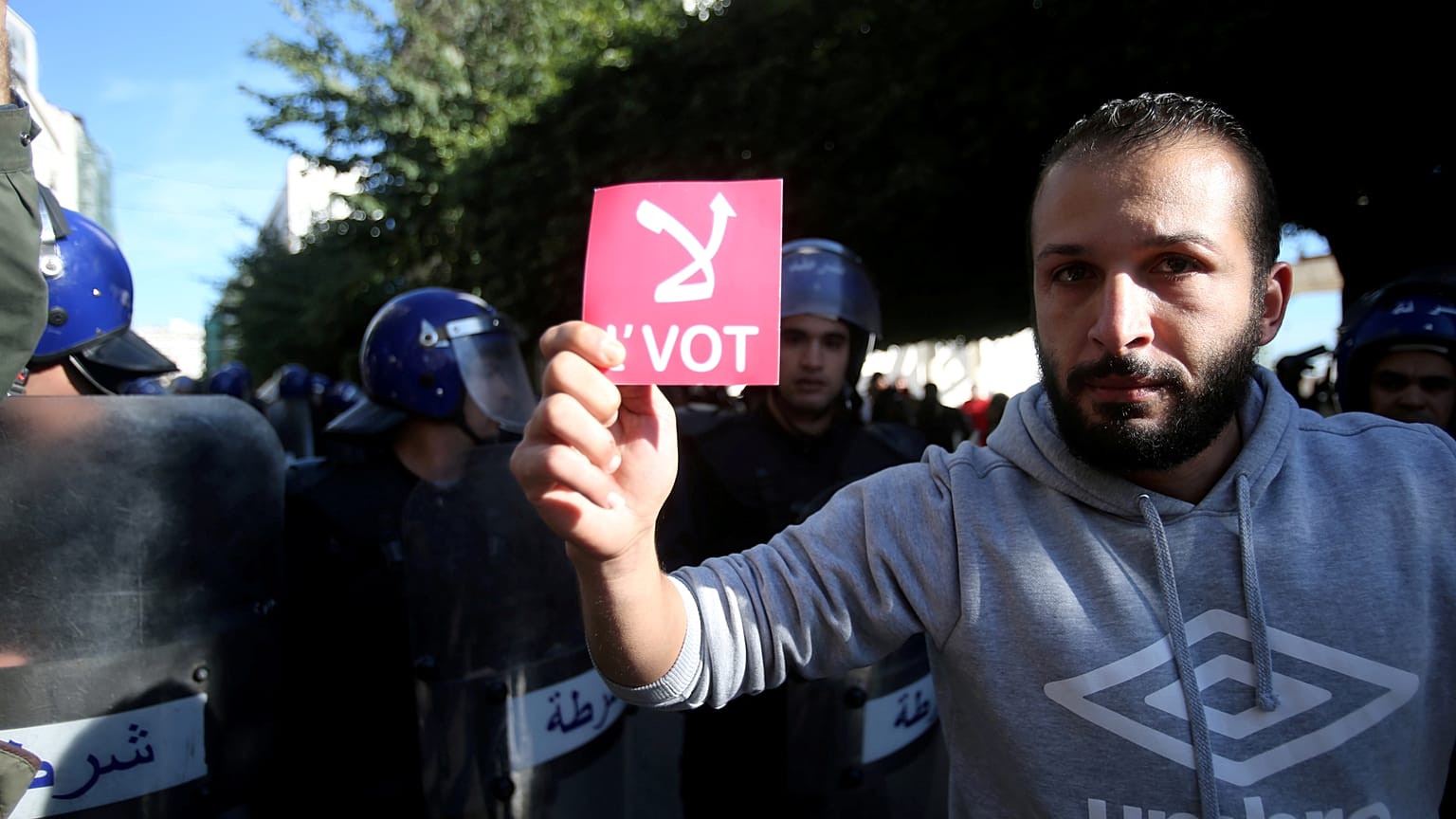 A demonstrator holds a card during a protest calling to reject the upcoming presidential election in Algiers, Algeria December 11, 2019. 
