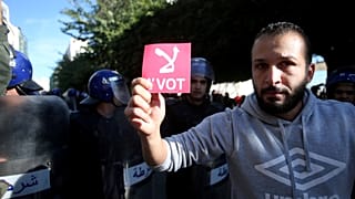 A demonstrator holds a card during a protest calling to reject the upcoming presidential election in Algiers, Algeria December 11, 2019. 