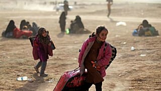 طفلة تمشي بالقرب من باغور في محافظة دير الزور في سوريا