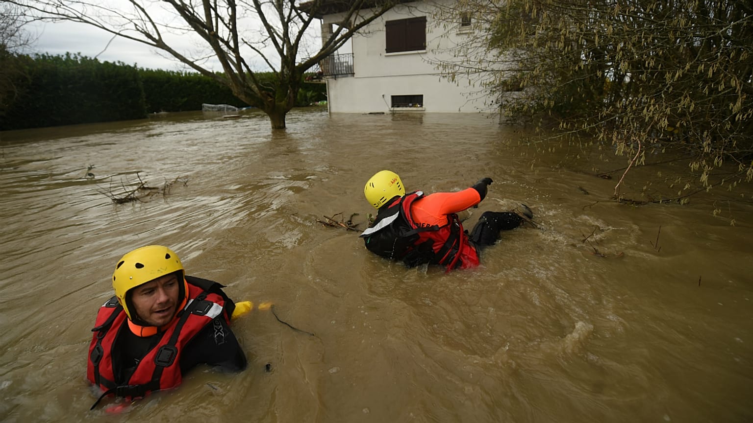 Equipas de bombeiros inspecionam um bairro inundado em Peyrehorade
