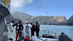Members of a dive squad conduct a search during a recovery operation around White Island