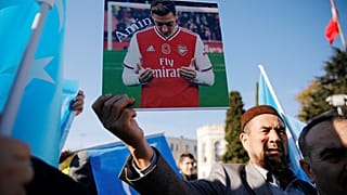 متظاهرة داعم لمسلمي الأيغور يحمل صورة أوزيل