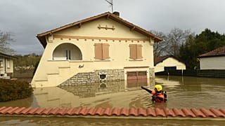Um bombeiro verifica a situação junto a uma casa de Peyrehorade afetada pelas cheias