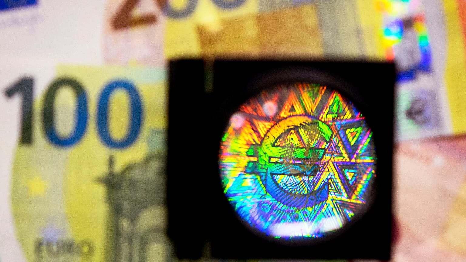 A loupe enlarges one of the security features of the new 100 and 200 Euro notes.