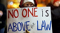 "Kimse hukuktan üstün değil" pankartı taşıyan kişi Trump'ın azledilmesini istiyor 