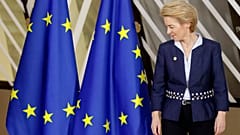 European Commission President Ursula von der Leyen looks at the EU flag prior to a group photo during an EU summit in Brussels, Thursday, Dec. 12, 2019.