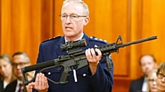 Police chief Mike McIlraith shows New Zealand MPs an AR-15 style rifle similar to one of the weapons a gunman used to kill 51 worshippers at two New Zealand mosques