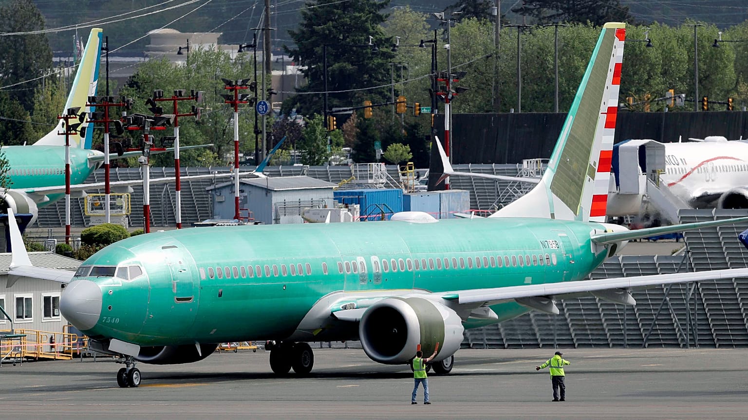 Workers stand near a Boeing 737 MAX built for American Airlines