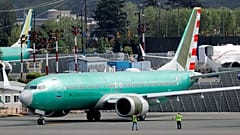 Workers stand near a Boeing 737 MAX built for American Airlines