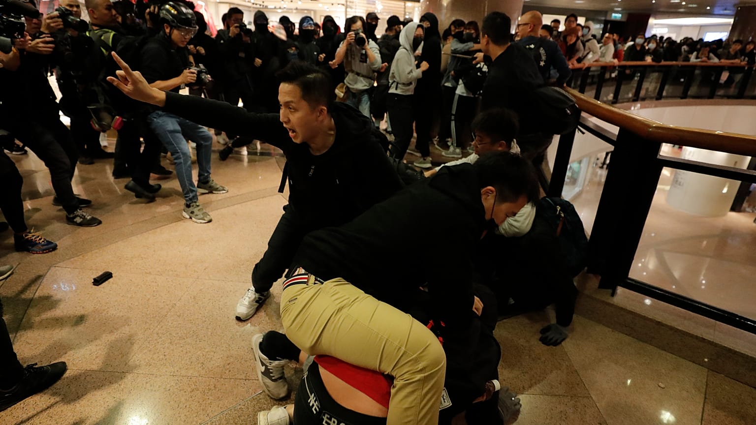 Plainclothes police officers arrest protesters in a Hong Kong mall.