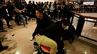 Plainclothes police officers arrest protesters in a Hong Kong mall.