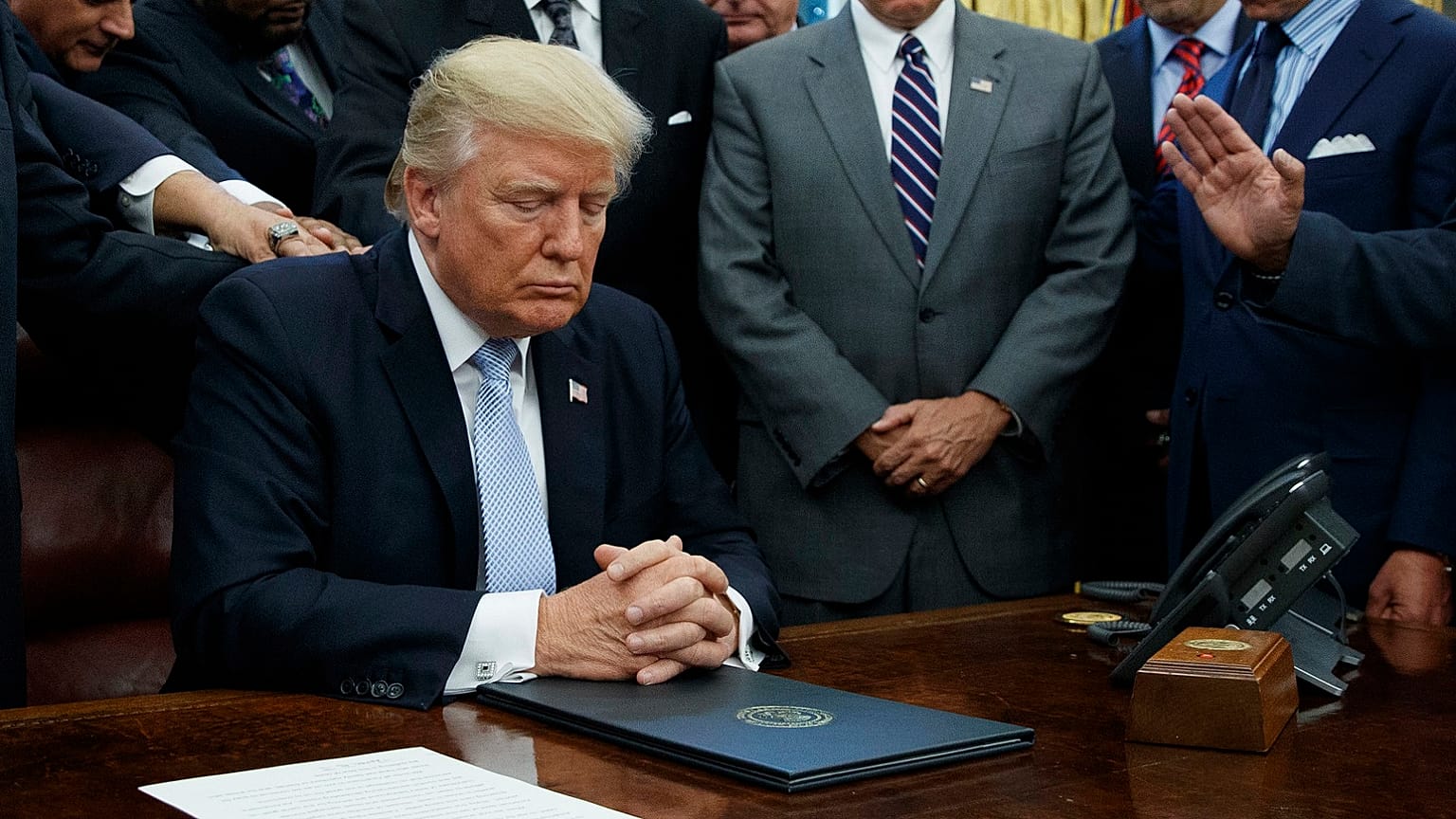 Faith leaders pray with President Donald Trump in the Oval Office of the White House