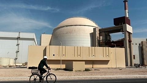 FILE. A worker rides a bicycle in front of the reactor building of the Bushehr nuclear power plant. 26 Oct. 2010.