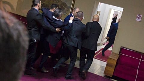 Police officers carry a pro-Serb opposition lawmaker in the parliament building in Podgorica, Montenegro, Friday, Dec. 27, 2019. 
