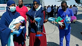 Medical personnel carry wounded children to be airlifted to the Turkish capital for treatment after they were injured in Saturday's car bomb blast in Mogadishu, Somalia.