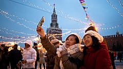 Tourists take a selfie in Red Square decorated for New Year celebrations, with the the Kremlin's Spasskaya Tower in the background, in Moscow, Russia.