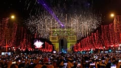 Revellers photograph fireworks over the Arc de Triomphe as they celebrate the New Year on the Champs Elysees, in Paris, France, Wednesday, Jan. 1, 2020.