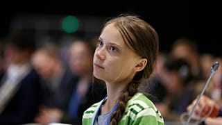 Swedish climate activist Greta Thunberg listens to speeches before addressing a plenary of UN climate conference at the COP25 summit in Madrid, Spain